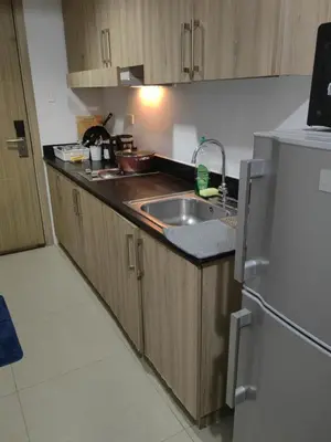 a kitchen with a sink and a refrigerator at lhey's staycation in Manila