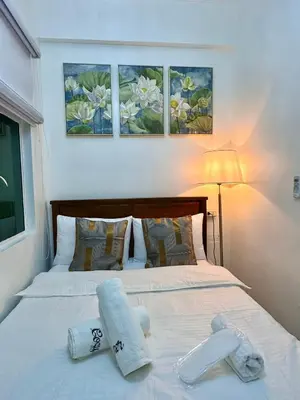 a bedroom with a bed with two towels on it at Studio Two Condominium, Alabang - GOLD FIBER WI-FI -NETFLIX READY in Manila