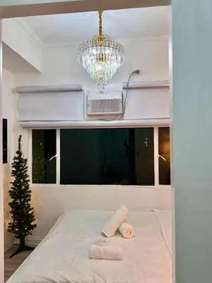 a bedroom with a christmas tree and a chandelier at Studio Two Condominium, Alabang - GOLD FIBER WI-FI -NETFLIX READY in Manila