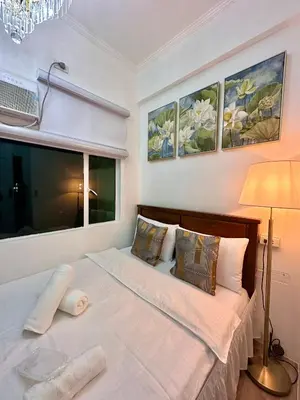 a bedroom with a large white bed with a window at Studio Two Condominium, Alabang - GOLD FIBER WI-FI -NETFLIX READY in Manila
