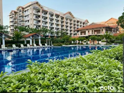 a hotel with a swimming pool in front of a building at Life in refinement at Ivory Wood in Manila
