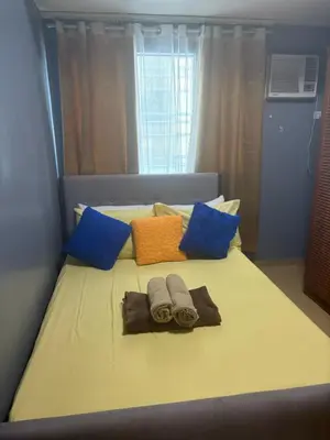 a bed with two towels and pillows on it at FamilyRoom 1 bedroom in Manila