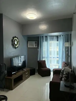 a living room with a couch and a television at FamilyRoom 1 bedroom in Manila