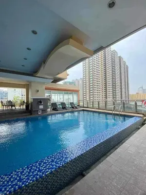 a large swimming pool on top of a building at Birch Tower Malate Manila by T&T in Manila