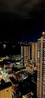 a night view of a city with tall buildings at Birch Tower Malate Manila by T&T in Manila