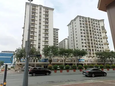 two tall buildings with cars parked in a parking lot at Condo Near MOA and NAIA at SoleMare Parksuites in Manila