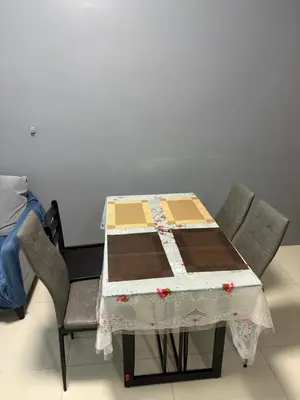 a table with two chairs and a table with a quilt on it at Family budget room, infront US of Embassy in Manila