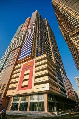 a tall building with a sign on the side of it at Cozy simple 1 bedroom in Manila