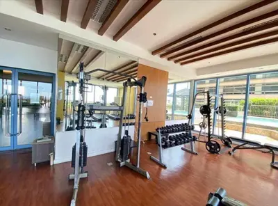 a gym with several treadmills and machines in a room at Cozy simple 1 bedroom in Manila