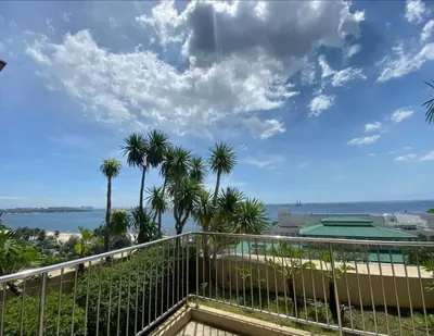 a balcony with a view of the ocean and palm trees at Cozy simple 1 bedroom in Manila