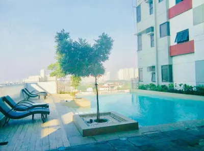 a tree sitting next to a swimming pool on a building at Pent House for Your Staycation in Manila
