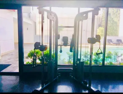 a gym with a view of a pool through the windows at Pent House for Your Staycation in Manila