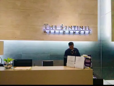 a man standing behind a counter in an office at Pent House for Your Staycation in Manila