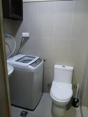 a small bathroom with a toilet and a sink at Breeze Residences in Manila