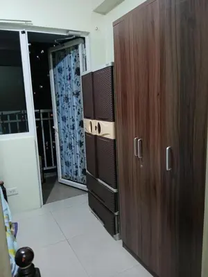 a large wooden cabinet in a room with a door at Breeze Residences in Manila