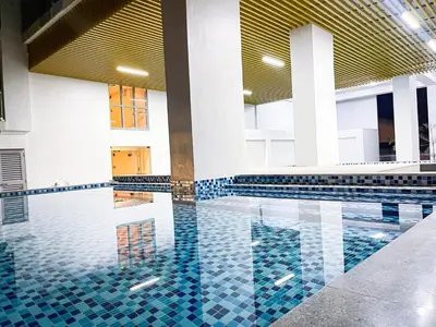 a swimming pool with blue tiles in a building at Lovely Penthouse near Airport, City of Dreams 8pax in Manila