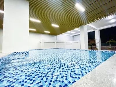 a swimming pool with blue tiles on the floor at Lovely Penthouse near Airport, City of Dreams 8pax in Manila