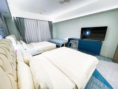 a hotel room with two beds and a flat screen tv at Lovely Penthouse across City of Dreams, Airport in Manila