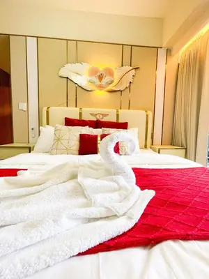 a bedroom with a bed with white sheets and a swan on it at Cozy 3BR in Manila Bay near Okada II 12pax in Manila