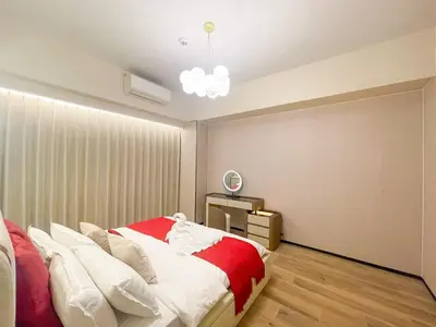 a bedroom with a bed with white and red sheets at Cozy 3BR in Manila Bay near Okada II 12pax in Manila