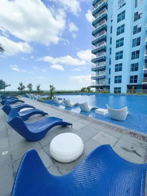 a row of blue chairs next to a swimming pool at Cozy 3BR in Manila Bay near Okada II 12pax in Manila