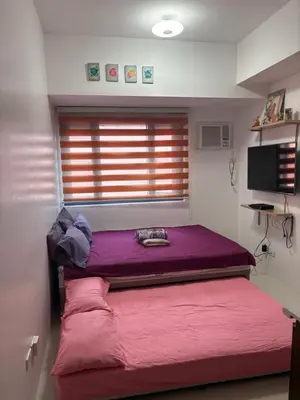 a bedroom with a purple bed and a window at Studio type unit 1, infront of US Embassy Manila in Manila