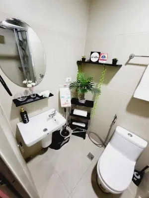 a bathroom with a sink and a toilet and a mirror at Mavic Staycation in Manila