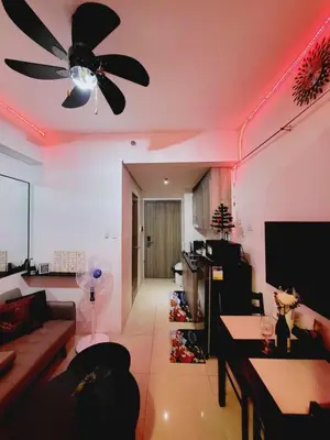 a living room with a ceiling fan and pink lighting at Mavic Staycation in Manila