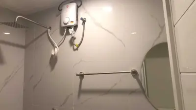 a bathroom with a mirror and a camera on the wall at OYO 1128 HOTEL SANGCO in Manila