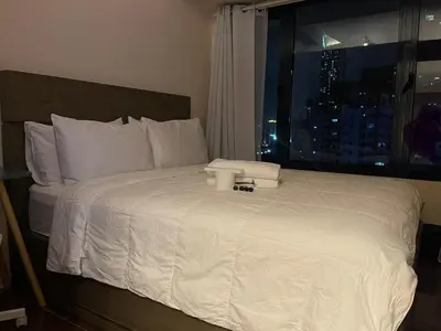 a bedroom with a large white bed with a window at Destina at Air Residence Makati, MetroManila, Netflx in Manila