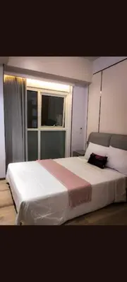 a bedroom with a large white bed with a window at One winstar realty corp in Manila
