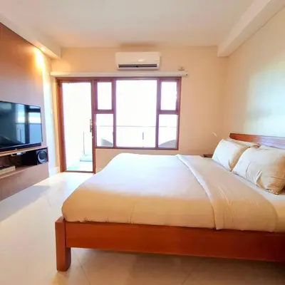 a bedroom with a large bed and a television at STAYLUXIA BOUTIQUE HOTEL MANILABAYVIEW - 1-5 BR Luxury and Superior Condos with, Balcony, Pool, Netflix & Gym- Housekeeping Available - in Manila