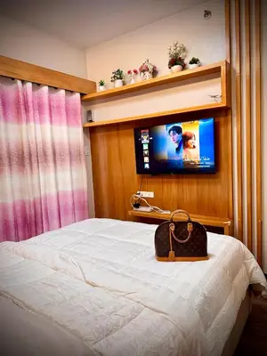 a hotel room with a bed and a television at The Cozysweet Homestay in Manila