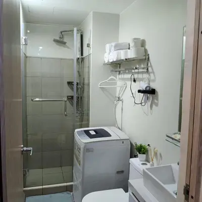 a bathroom with a shower and a toilet and a sink at Field Residence Cozy Condo In Paranaque in Manila