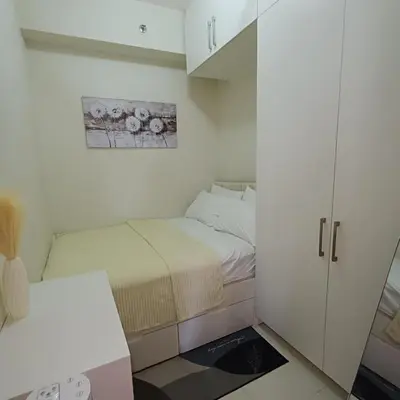 a small room with two beds and a cabinet at Field Residence Cozy Condo In Paranaque in Manila