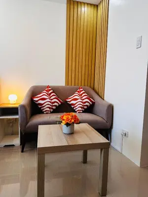 a living room with a couch and a coffee table at 1232A Near MOA and Airport Pool View Balcony in Manila