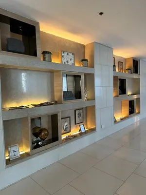 a living room with a wall of shelves at 729A Near MOA and Airport PoolView Balcony in Manila