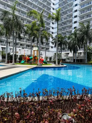 a large swimming pool with a playground in front of a building at 729A Near MOA and Airport PoolView Balcony in Manila