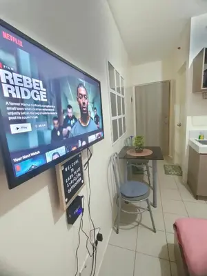 a flat screen tv hanging on a wall in a kitchen at Gaby's Condotel in Manila