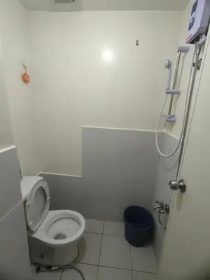 a small bathroom with a toilet and a shower at Gaby's Condotel in Manila