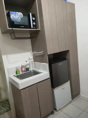 a small kitchen with a sink and a microwave at Gaby's Condotel in Manila