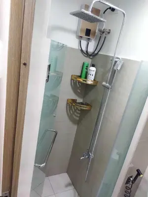 a shower with a glass door in a bathroom at JAS Staycation in Manila