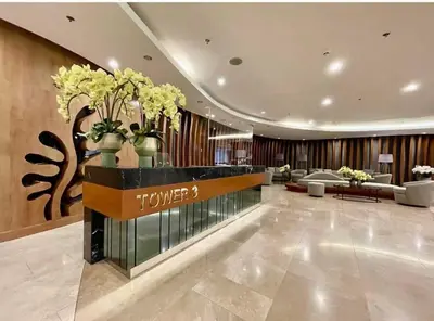 a hotel lobby with a reception desk with vases of flowers at JAS Staycation in Manila