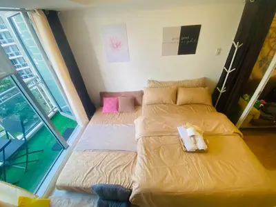 a bedroom with two beds and a large window at Sole Sisters Staycation in Manila
