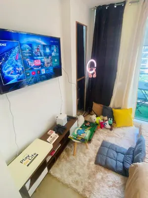 a living room with a tv and a couch at Sole Sisters Staycation in Manila