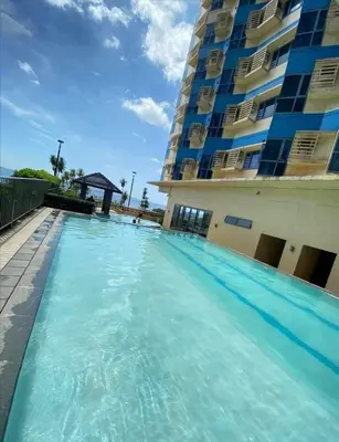 a swimming pool in front of a building at Family Budget Room in Manila
