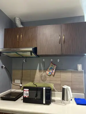 a kitchen counter with a microwave on a counter top at Family Budget Room in Manila