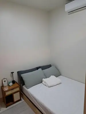 a small room with a bed and a night stand at Yutori Haus at Shore 3 Tower 2 near Mall of Asia Pasay City in Manila
