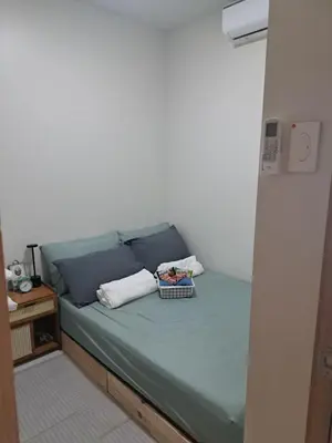 a bed with two pillows and a basket on it at Yutori Haus at Shore 3 Tower 2 near Mall of Asia Pasay City in Manila