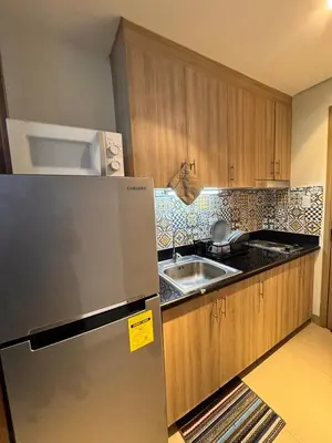 a kitchen with a refrigerator and a sink at Iris Suites in Manila